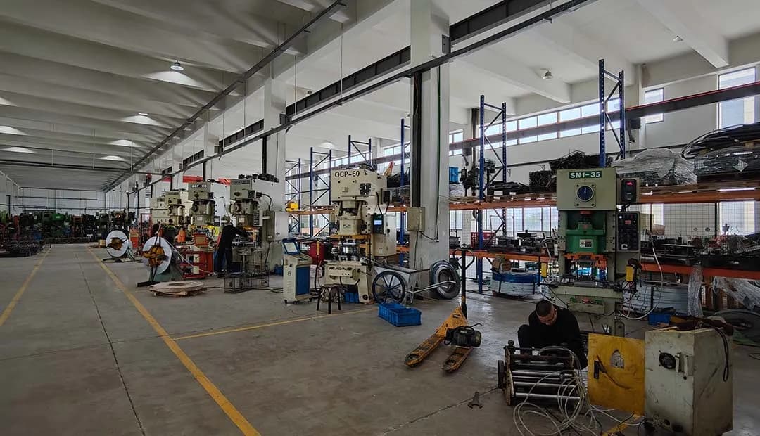 In the stamping workshop, the maintenance technician is repairing the feeders and adjusting the molds.