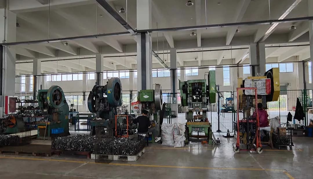 Workers are operating single-station punching dies for stamping.