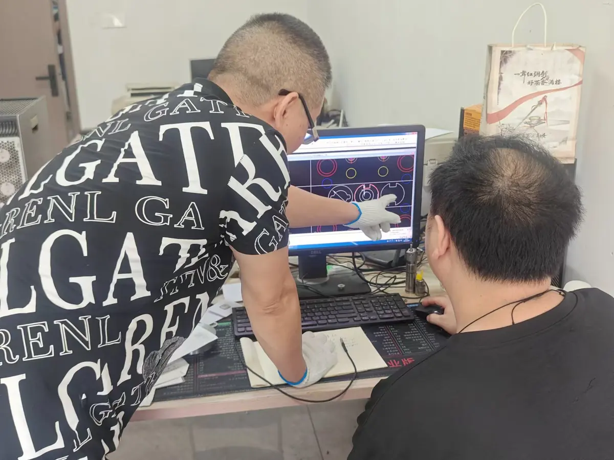 Ingenieros de utillaje y producción revisando una pieza estampada de prueba