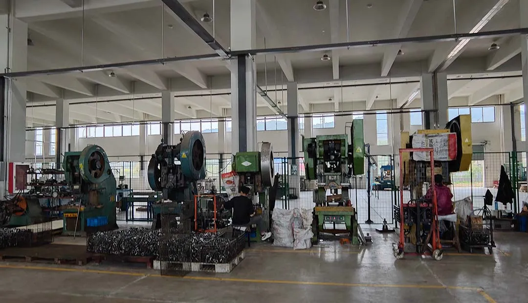 Workers are operating single-station punching dies for stamping.
